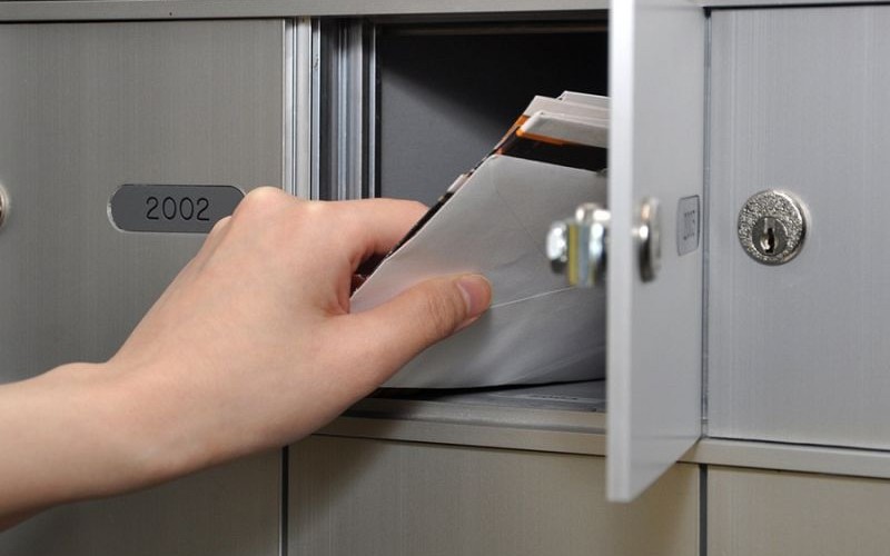 hand putting mail into a private mailbox